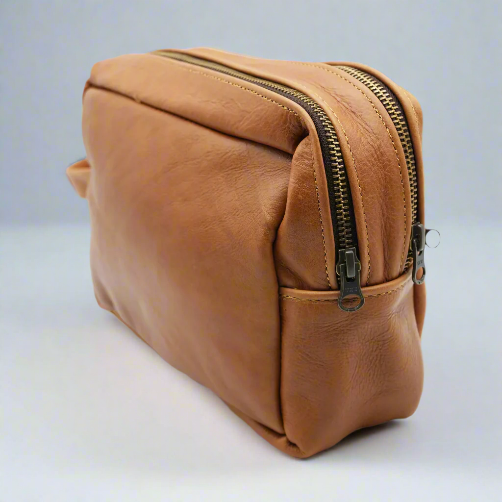 Brown leather toiletry bag on a white background